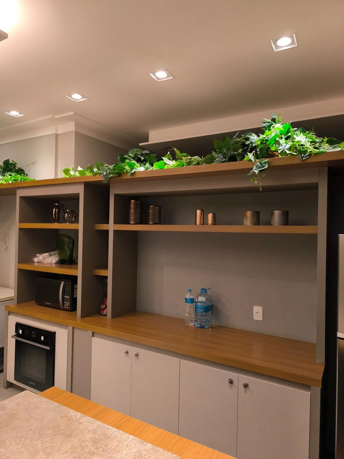 Marcenaria sob medida com nichos, iluminação e acabamento amadeirado